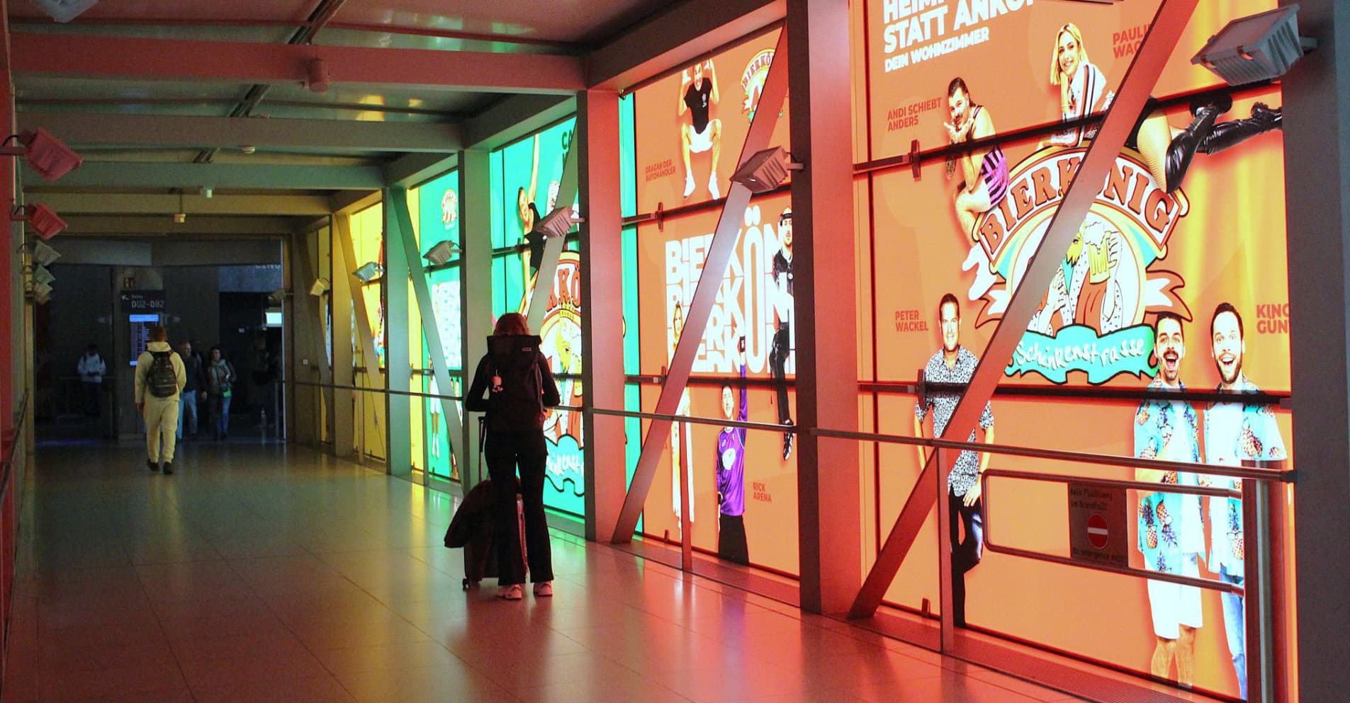 Pasillo de la terminal del aeropuerto de Mallorca con paneles publicitarios retroiluminados en las paredes